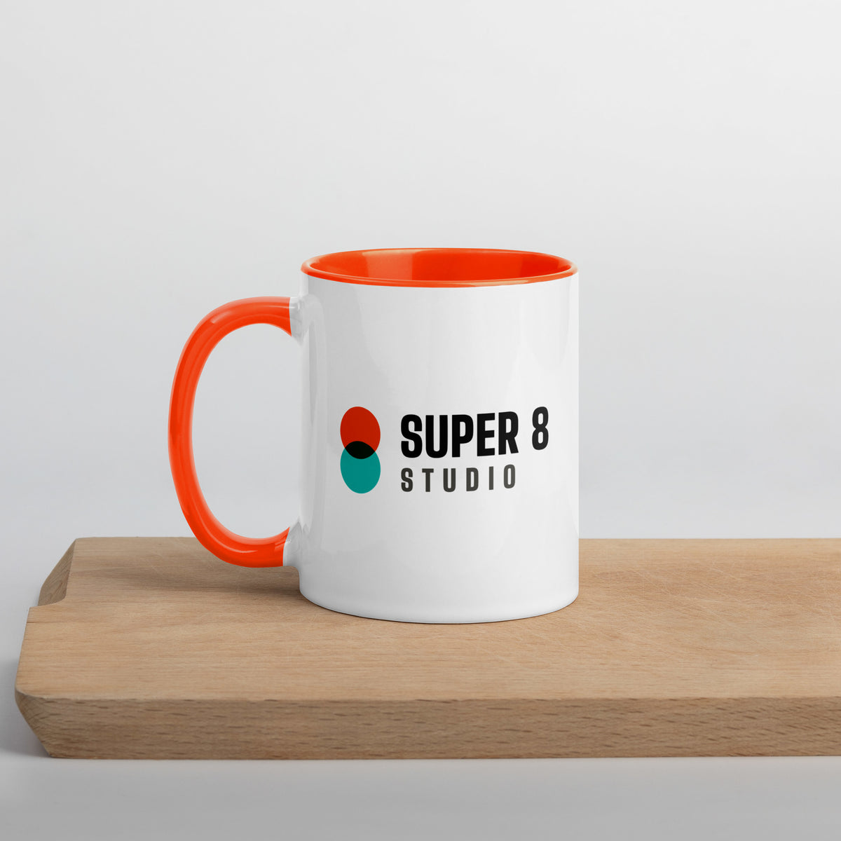 Super 8 Studio mug with an orange inside and handle, showing the full-colour Super 8 Studio logo